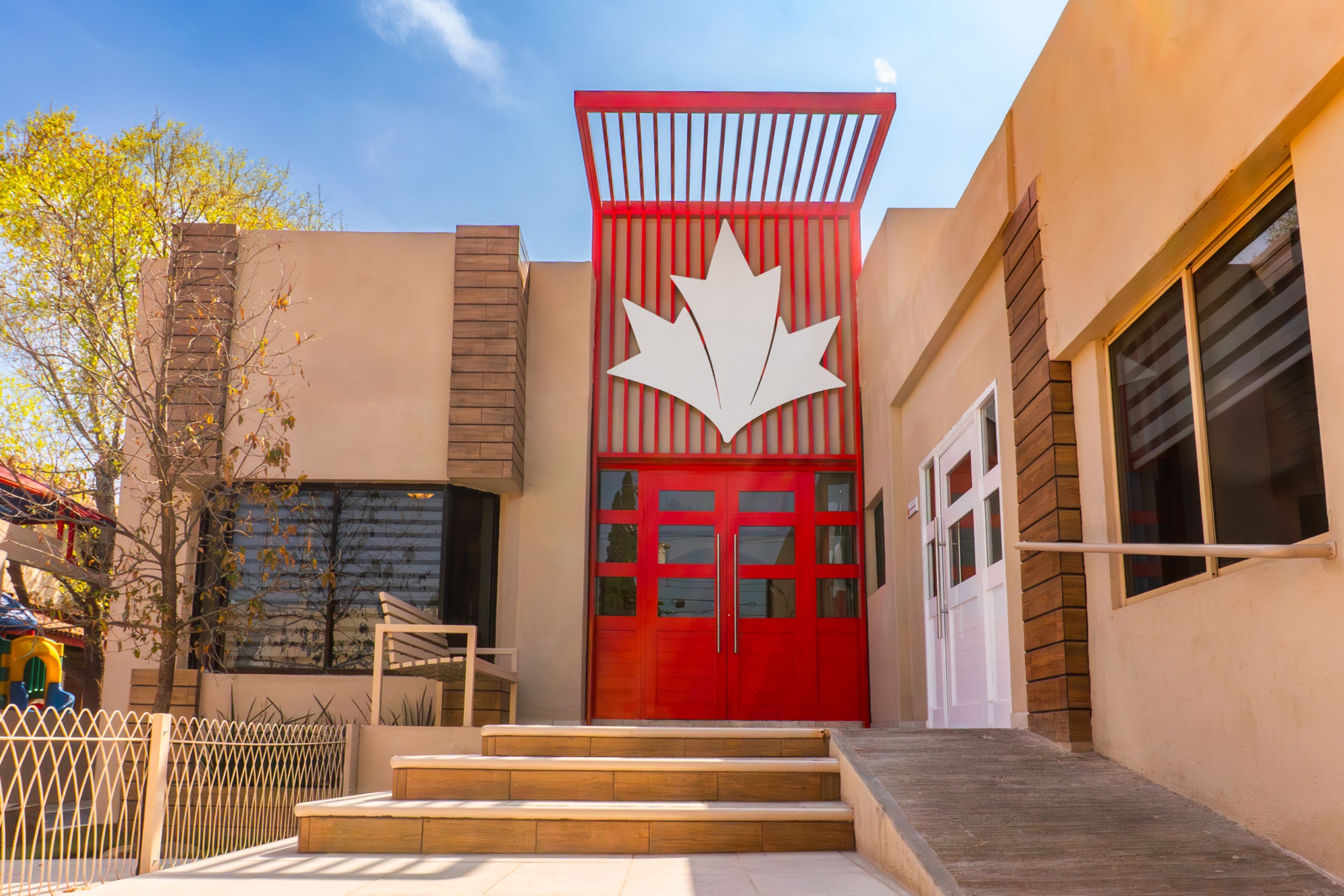 Entrada principal de Maple College Saltillo, con la hoja de maple sobre el acceso rojo